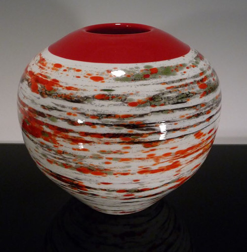 An earthenware vessel with a red and white abstract pattern