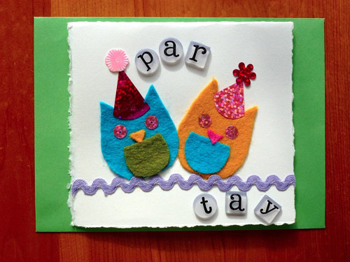A paper card with felted owls attached to the front