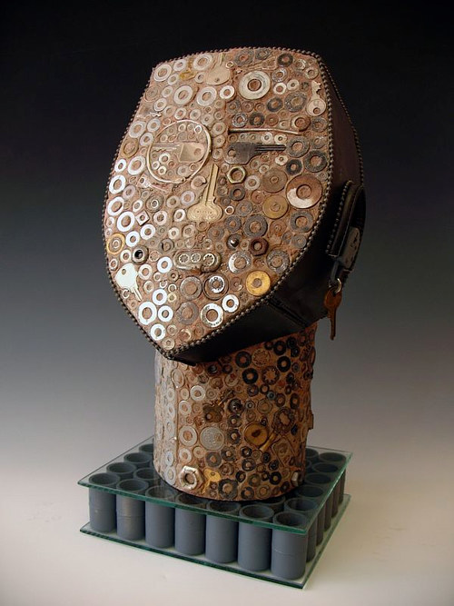 A sculpture adorned with a variety of small metallic pieces