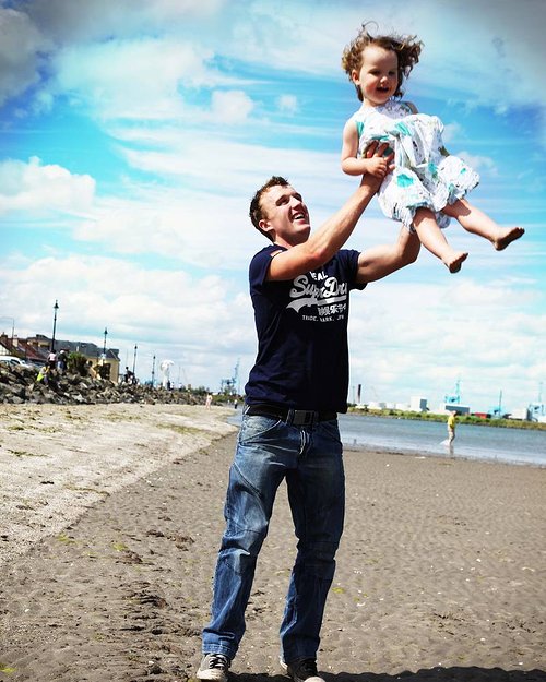 A photograph of a father holding his daughter up