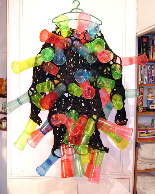 A costume made from a black mesh garment and coloured plastic cups
